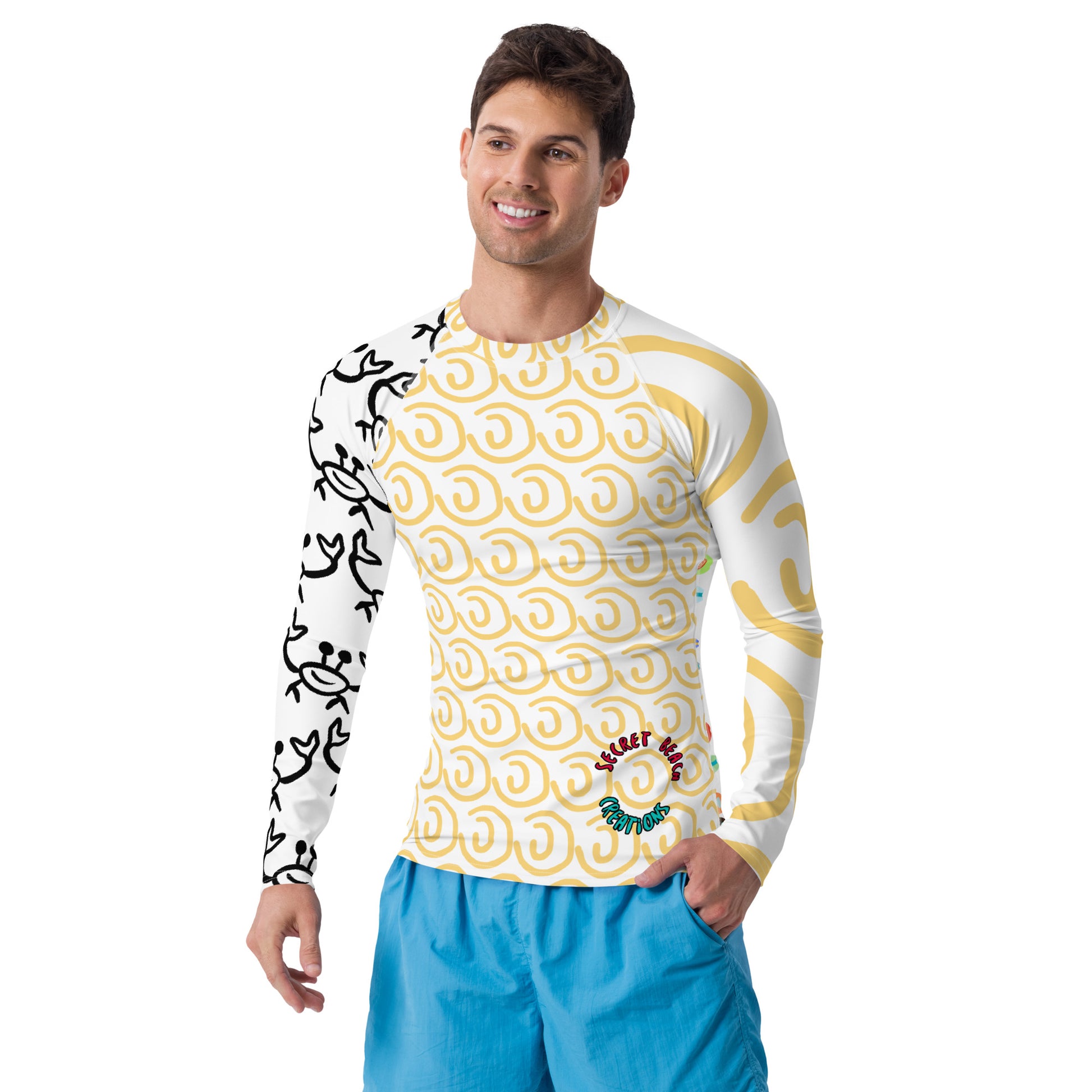 Image of a white long sleeve rash guard with yellow sun lines on one sleeve, the outline of a happy ghost crab on the other, a yellow sun outline pattern in the front with the words "Secret Beach Creations" on the lower right and a repeating paddle board pattern in the back.