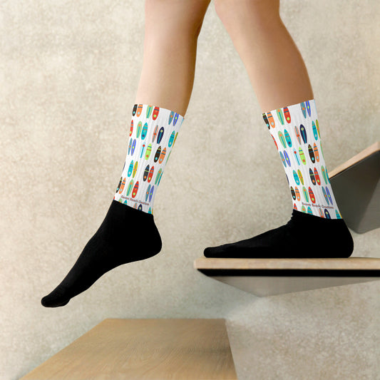 Image of socks with a black foot and white legs with paddle boards printed on the top half.