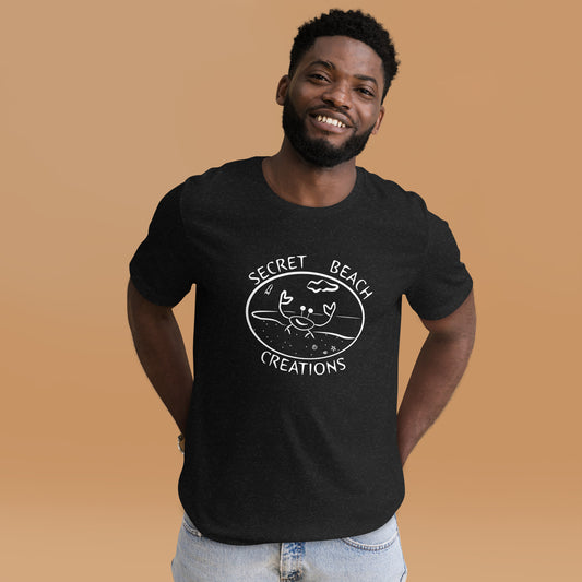 Image of a black heather color t-shirt with a white outline design of a ghost crab on a beach with a rocket lifting off in the background with the words "Secret Beach Creations".